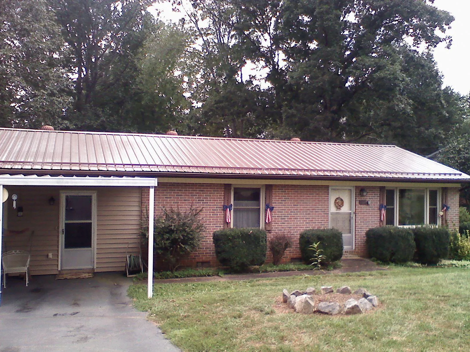 Bronze metal roof and carport on a brick ranch home — Roof Repair work by our crew in Spring Grove